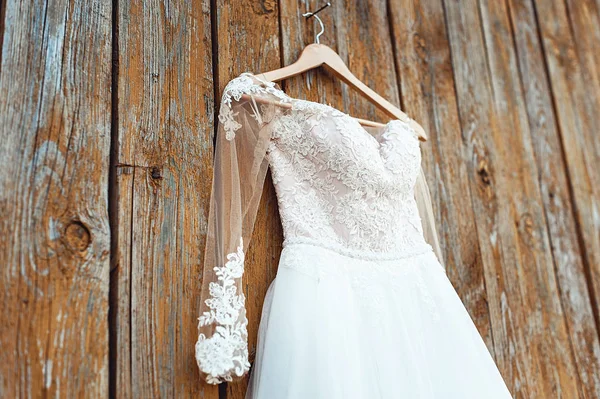 Vestido de casamento bege no rack na parede de madeira amarela com tinta rachada — Fotografia de Stock