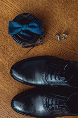 Modern insan aksesuarları, yakın çekim. Mavi papyon, deri ayakkabı, kemer ve kol düğmeleri