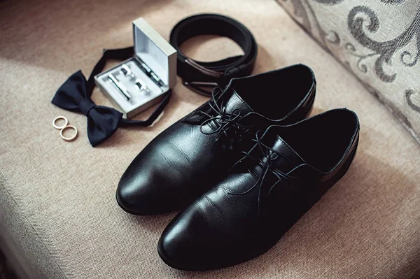 Gros plan sur les accessoires homme moderne. alliances, noeud papillon noir, chaussures en cuir, ceinture et boutons de manchette — Photo