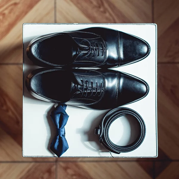 Gros plan sur les accessoires homme moderne. noeud papillon noir, chaussures en cuir et ceinture . — Photo