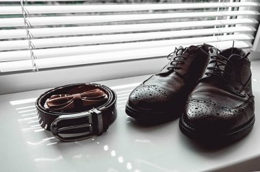 Kahverengi papyon, deri ayakkabı ve kemer. Düğün sabah mamülleri. Modern insan aksesuarları, yakın çekim