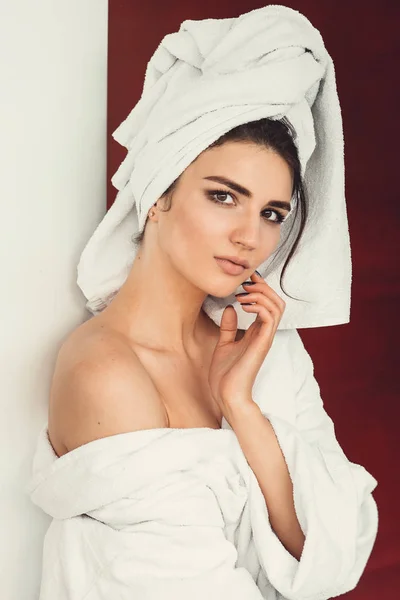 Sexy ragazza con i capelli scuri, grandi occhi e sopracciglia scure indossando accappatoio bianco whith asciugamano sulla testa . — Foto Stock