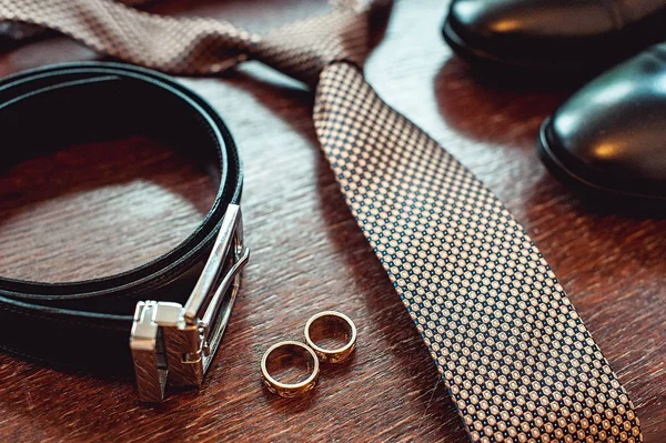 Κοντινό πλάνο, μοντέρνα ιπποκόμος αξεσουάρ. γαμήλια δαχτυλίδια, γραβάτα, δερμάτινα παπούτσια και ζώνη — Φωτογραφία Αρχείου