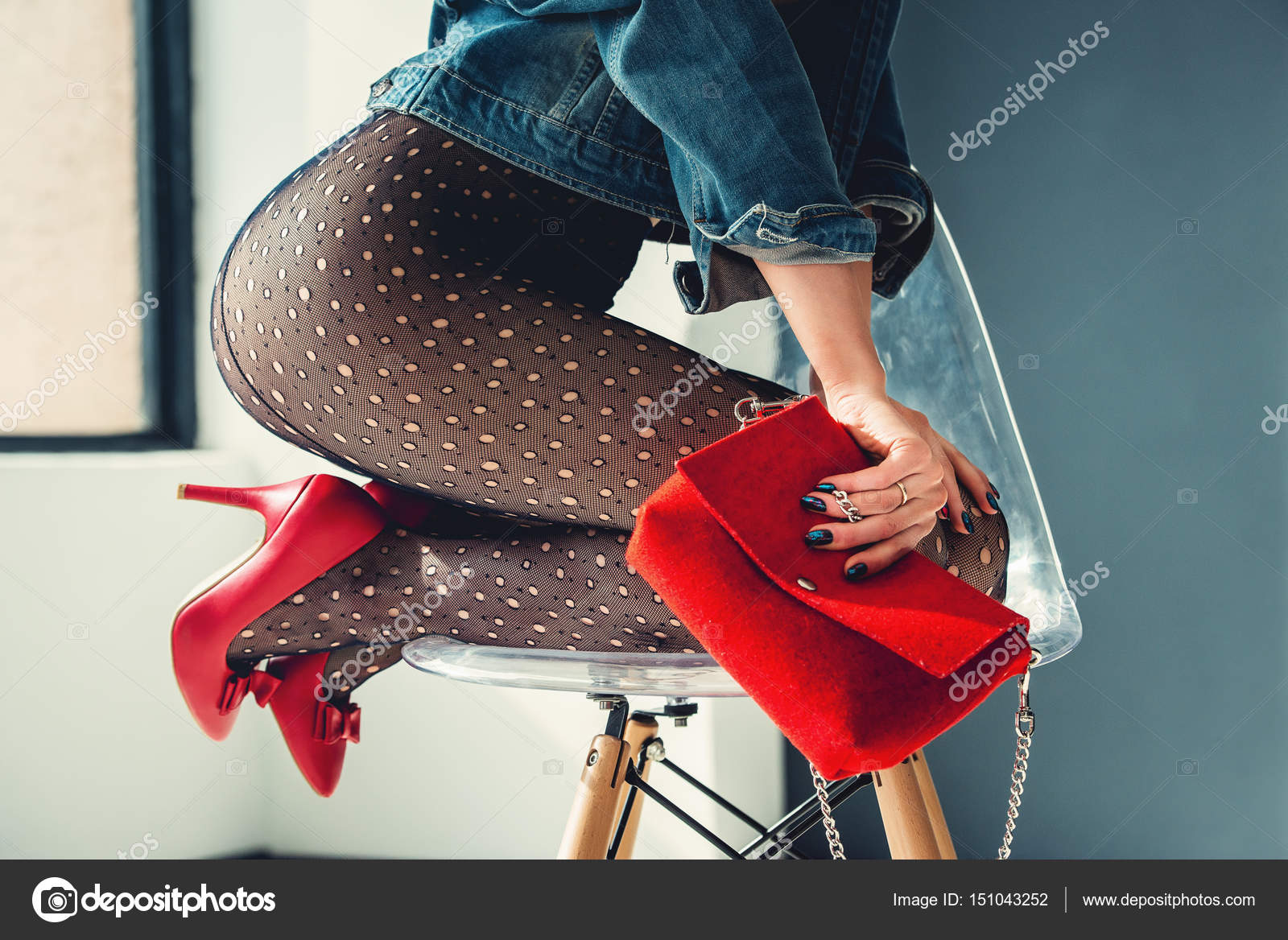 Magnifique fille vêtue d\u0027une chaussures à talons hauts bleu jeance veste, rouge avec rouge petit sac et collants transparents sans culotte. posant assis sur