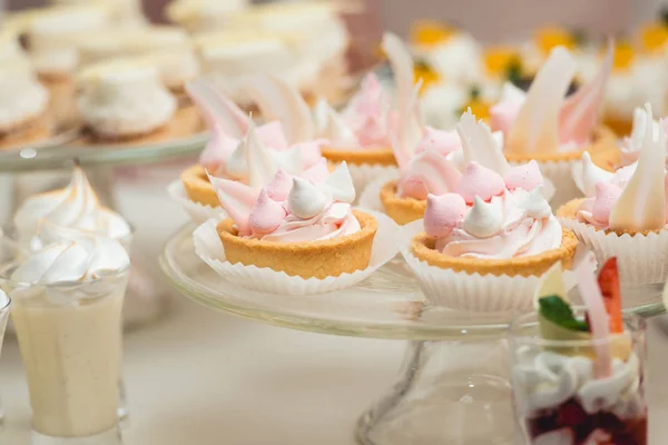 Suporte de vidro com cupcakes em uma mesa de bar de doces de casamento — Fotografia de Stock