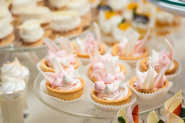 Suporte de vidro com cupcakes em uma mesa de bar de doces de casamento — Fotografia de Stock