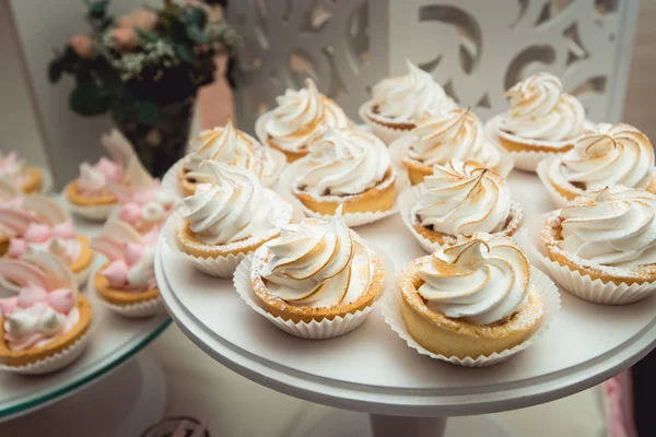 Suporte de vidro com cupcakes em uma mesa de bar de doces de casamento — Fotografia de Stock