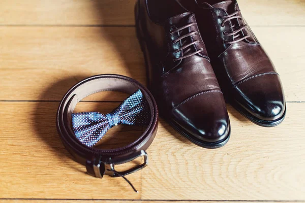 Reloj, corbata de lazo marrón, zapatos de cuero y cinturón. Mañana de bodas de novios. Primer plano de los accesorios hombre moderno — Foto de Stock