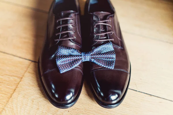 Laço azul gravata em um couro sapatos castanhos. Manhã de casamento dos noivos. Close up de acessórios do homem moderno — Fotografia de Stock