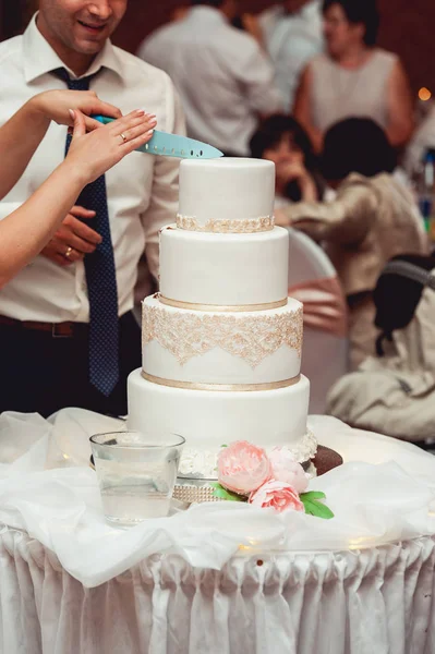 Свадебная церемония. невеста и жених делают свой первый кейс вместе, вырезают свадебный торт — стоковое фото