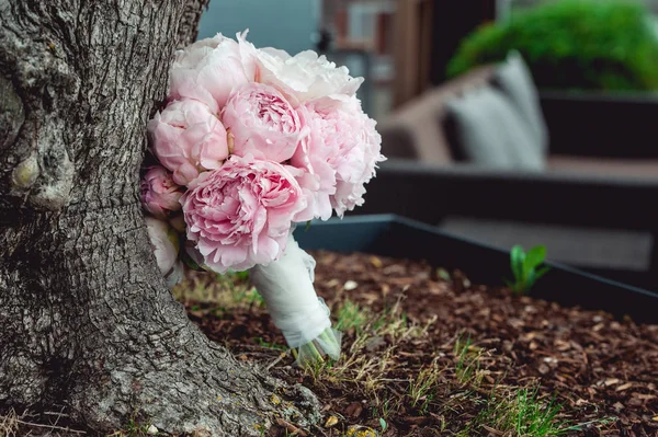Розкішний весільний букет з білих півоній і троянд біля дерева — стокове фото