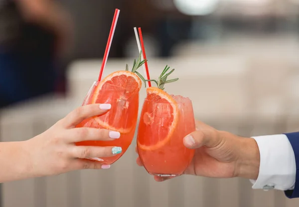 People hold in hands glasses with orange cocktail. wedding party.