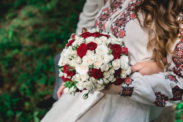Sposa tenere in mano bouquet da sposa di biege e rose rosse . — Foto Stock