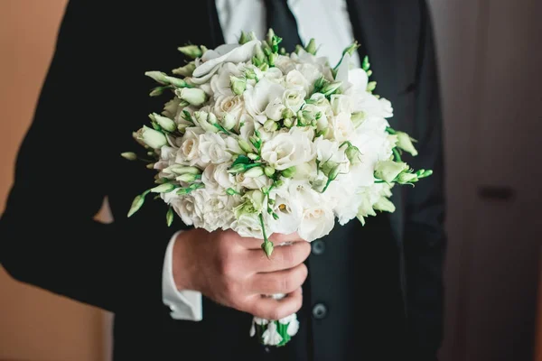 Наречена в чорному костюмі з краваткою тримає весільний букет з білих троянд — стокове фото