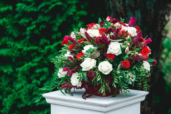 Cerimônia de casamento. Coluna, decorada com buquê de rosas vermelhas e brancas, na área da cerimônia de casamento — Fotografia de Stock