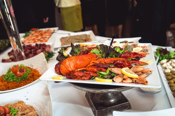 Excelente selecção de crustáceos para o jantar. Lagosta, caranguejo e camarão jumbo em um prato branco — Fotografia de Stock