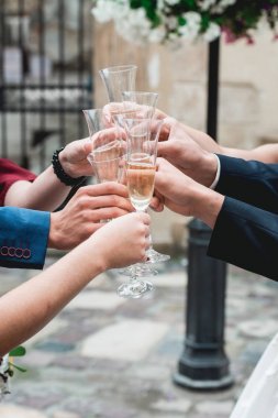 İnsanlar beyaz şarapla el ele tutuşuyorlar. düğün partisi.