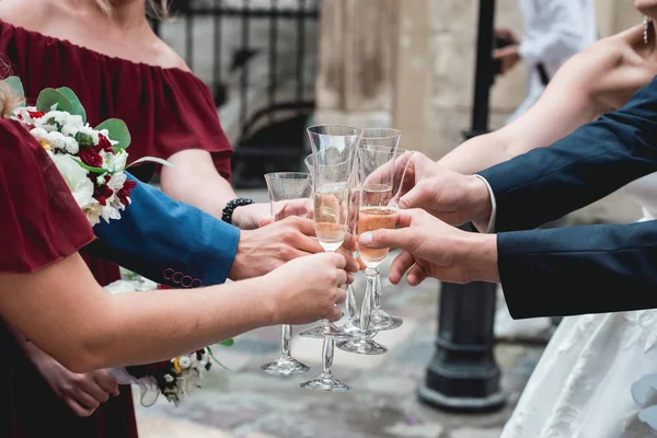 Die Menschen halten Gläser mit Weißwein in den Händen. Hochzeitsgesellschaft. — Stockfoto