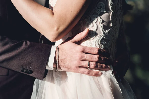 Kadın ve erkekte düğün açık havada huging elbise. Genç bir adam yavaşça onun gelin gelinlik kucaklayan — Stok fotoğraf