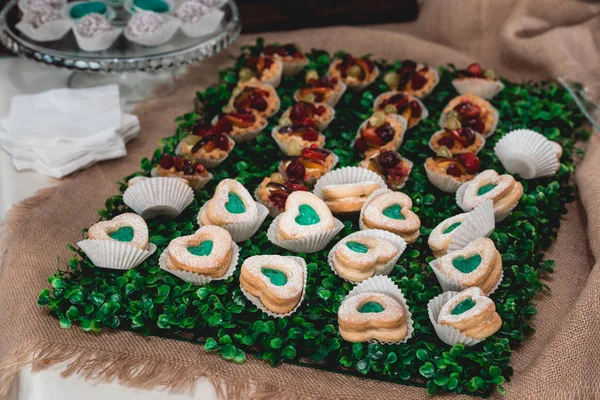 Deliciosos biscoitos corações doce sobremesa colorida verde e branco para festa de aniversário em uma barra de doces — Fotografia de Stock