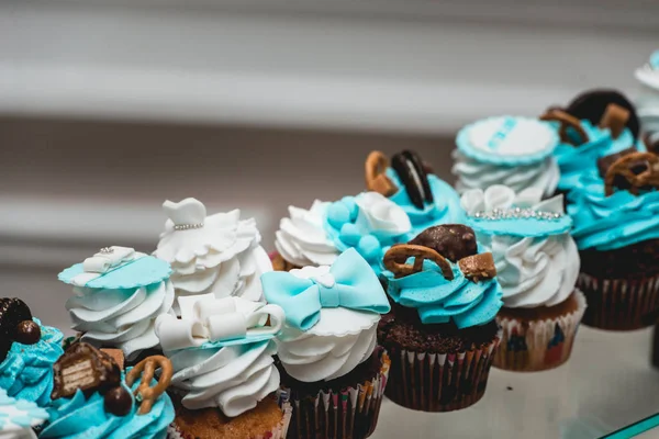 Fileiras de cupcake de aniversário com manteiga branca e azul creme de gelo em um suporte de vidro — Fotografia de Stock