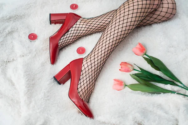 Sexy piernas femeninas en zapatos rojos de tacón alto y medias de rejilla. Estilo retro —  Fotos de Stock