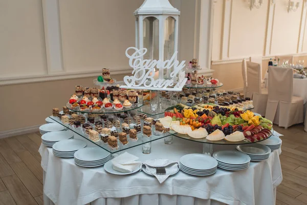 Candybar in un ristorante. Tavolo bianco decorato sciocco di pasticceria dolce — Foto Stock