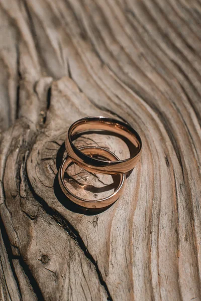 Par de anillos de oro de la boda en el fondo rústico de madera amarillo — Foto de Stock