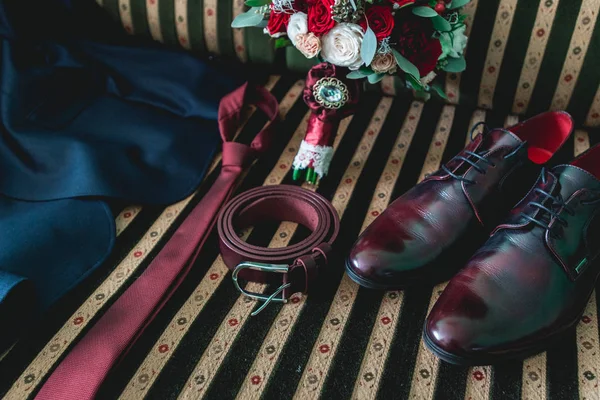 Ceinture, cravate, costume, chaussures et bouquet de mariage sur un canapé vintage — Photo