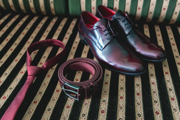 belt, necktie and shoes on a vintage sofa