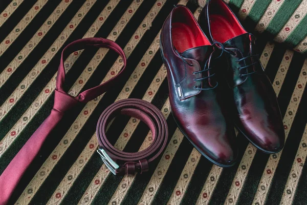 Ремень, галстук и обувь на винтажном диване — стоковое фото