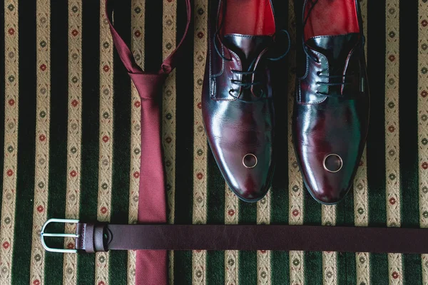 Cinturón, corbata y zapatos en un sofá vintage — Foto de Stock