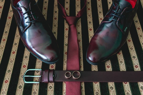 Ремень, галстук и обувь на винтажном диване — стоковое фото