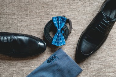 Takım elbise, mavi papyon, siyah deri ayakkabı ve kemer. Düğün sabah mamülleri. Modern insan aksesuarları, yakın çekim