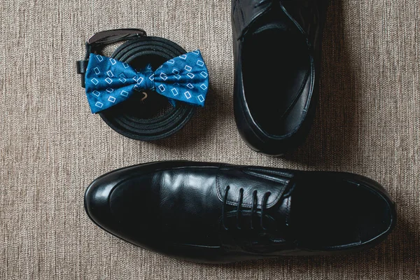 Μπλε παπιγιόν, Μαύρα δερμάτινα παπούτσια και ζώνη. Γαμπροί γάμου το πρωί. Κοντινό πλάνο του σύγχρονου ανθρώπου αξεσουάρ — Φωτογραφία Αρχείου