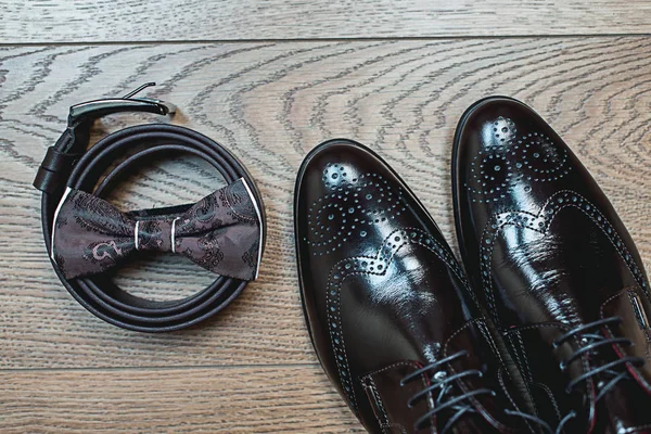 Corbata de lazo marrón se encuentra en un cinturón, zapatos de cuero. Los novios boda mañana — Foto de Stock