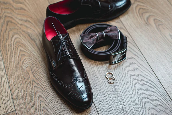 Brown bow tie lies on a belt, leather shoes. Grooms wedding morning — Stock Photo, Image