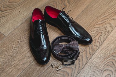 Kahverengi papyon yalanlar üzerine bir kemer, deri ayakkabılar. Düğün sabah mamülleri