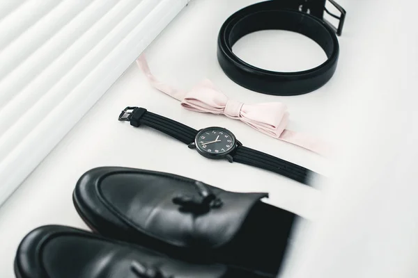 Gros plan sur les accessoires homme moderne. noeud papillon beige, chaussures en cuir noir, ceinture et montre — Photo