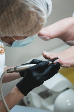 Elektrikli makine kullanan profesyonel donanım pedikürü. Tıbbi pedikür yapan hasta.,