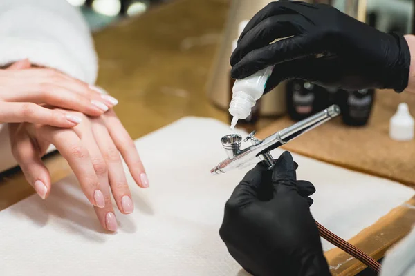 在指甲沙龙的一个女人的特写镜头接受了一个美容师与喷枪的指甲。女人得到指甲指甲. — 图库照片