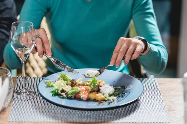 女性は、レストランで卵とおいしいサーモンのサラダを食べる。小さい部分 — ストック写真