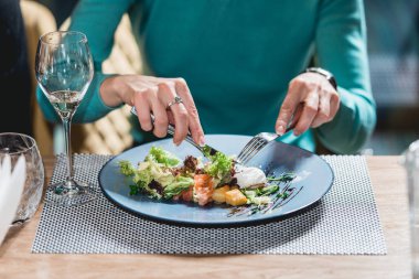 kadın bir restoranda lezzetli somon salata ile yumurta yiyor. küçük bir kısmı