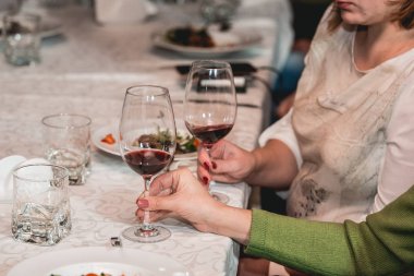 kadın kırmızı şarap tutar. insanlar şarap rengini düşünün ve nasıl farklı Gözlükte kokuyor deneyin