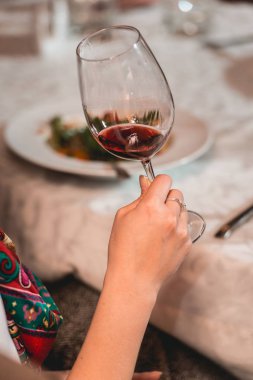 kadın kırmızı şarap tutar. insanlar şarap rengini düşünün ve nasıl farklı Gözlükte kokuyor deneyin