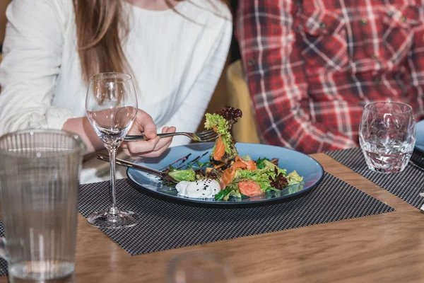 Женщина ест вкусный салат из лосося с яйцом в ресторане. небольшая порция — стоковое фото