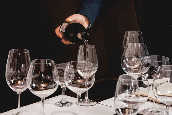 Sommelier a la cata de vinos verter el vino de una botella en una copa en la cata de vinos — Foto de Stock