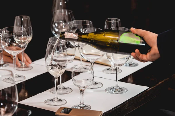 Sommelier all'atto di degustazione di vino versando vino da una bottiglia in un bicchiere all'atto di degustazione di vino — Foto Stock