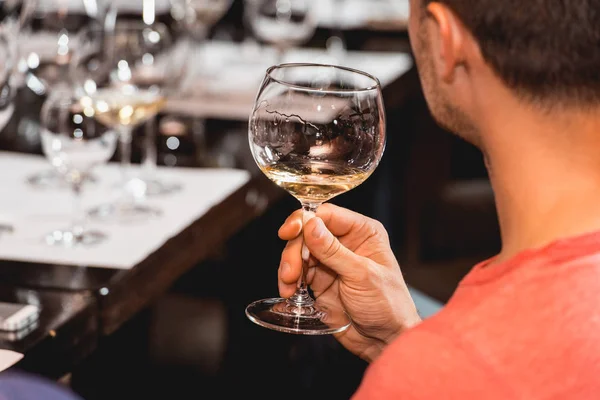 男は、赤ワインのガラスを保持します。人は、ワインの色を考慮してどのように異なるガラスのにおいがします。 — ストック写真