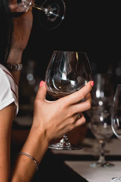 Mujer sostiene una copa de vino tinto. la gente considera el color del vino y probar cómo huele en diferentes vasos — Foto de Stock